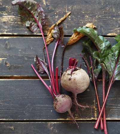 Agriculture.A group of beets with tops on a dark wooden background.の写真素材
