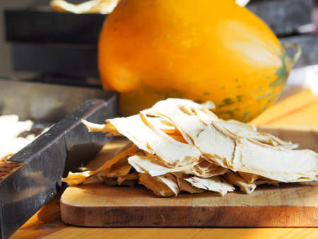 Autumn healthy natural fruit food. Dried melon wedges against a background of dark grates from a home dryer. We dry melons for future use.の写真素材