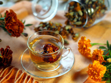 Herbal healthy tea from marigolds. Dried and fresh flowers on an autumn wooden background.の写真素材