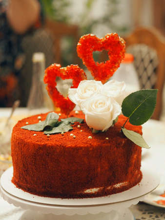 Festive cake, decorated in the style of a ruby wedding, with red hearts and delicate roses.の写真素材