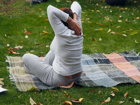 An elderly woman practices yoga in the fresh air. Yoga practice revives us to life, restores moral...