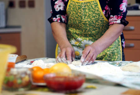 Woman in the kitchen kneads dough, close up photo. Healthy homemade food concept.の写真素材