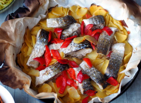 Chum salmon baked with potatoes and vegetables in the kitchen oven using baking paper. Healthy...
