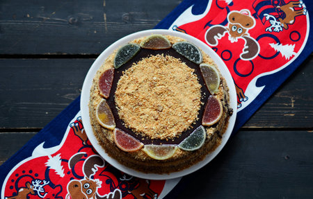 Food background in rustic style. Homemade round layered honey cake on a bright napkin against a dark...