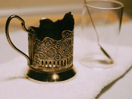 Faceted Glass and Cup holder. Cup holder appeared on the Russian railway in 1892.Metal coaster as a retoro relic of the Russian railway. Use the services on the road.の写真素材