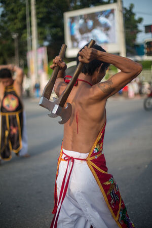 PHUKET, THAILAND ? October 1: Unidentified Mah song pierced weapon to their cheeks, They believed to suffer the pain of devotee during the Phuket Vegetarian Festival. The Festival is a famous annual festival also known as Nine Emperor Gods festival on theのeditorial素材
