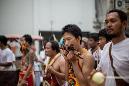 PHUKET, THAILAND - SEPTEMBER 30: Unidentified Mah song pierced weapon to their cheeks, They believed to suffer the pain of devotee during the Phuket Vegetarian Festival. The Festival is a famous annual festival also known as Nine Emperor Gods festival on のeditorial素材
