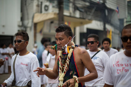 PHUKET, THAILAND - SEPTEMBER 30: Unidentified Mah song pierced weapon to their cheeks, They believed to suffer the pain of devotee during the Phuket Vegetarian Festival. The Festival is a famous annual festival also known as Nine Emperor Gods festival on のeditorial素材