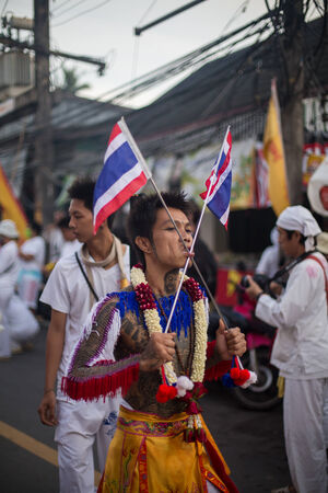 PHUKET, THAILAND ? October 1: Unidentified Mah song pierced weapon to their cheeks, They believed to suffer the pain of devotee during the Phuket Vegetarian Festival. The Festival is a famous annual festival also known as Nine Emperor Gods festival on theのeditorial素材