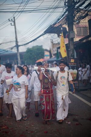 PHUKET, THAILAND ? October 1: Unidentified Mah song pierced weapon to their cheeks, They believed to suffer the pain of devotee during the Phuket Vegetarian Festival. The Festival is a famous annual festival also known as Nine Emperor Gods festival on theのeditorial素材