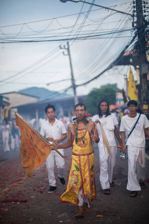 PHUKET, THAILAND ? October 1: Unidentified Mah song pierced weapon to their cheeks, They believed to suffer the pain of devotee during the Phuket Vegetarian Festival. The Festival is a famous annual festival also known as Nine Emperor Gods festival on theのeditorial素材