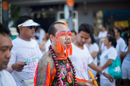PHUKET, THAILAND ? October 1: Unidentified Mah song pierced weapon to their cheeks, They believed to suffer the pain of devotee during the Phuket Vegetarian Festival. The Festival is a famous annual festival also known as Nine Emperor Gods festival on theのeditorial素材