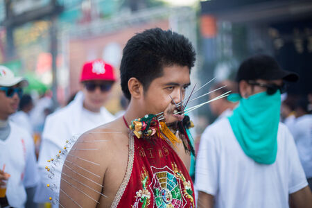 PHUKET, THAILAND ? October 1: Unidentified Mah song pierced weapon to their cheeks, They believed to suffer the pain of devotee during the Phuket Vegetarian Festival. The Festival is a famous annual festival also known as Nine Emperor Gods festival on theのeditorial素材