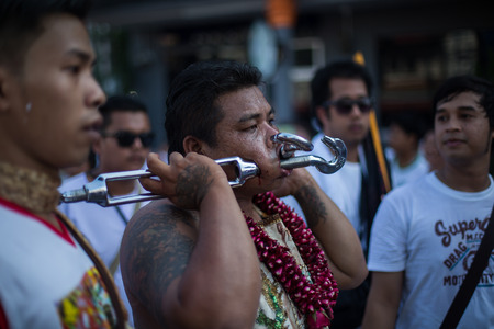 PHUKET, THAILAND ? October 1: Unidentified Mah song pierced weapon to their cheeks, They believed to suffer the pain of devotee during the Phuket Vegetarian Festival. The Festival is a famous annual festival also known as Nine Emperor Gods festival on theのeditorial素材