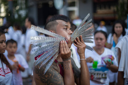 PHUKET, THAILAND ? October 1: Unidentified Mah song pierced weapon to their cheeks, They believed to suffer the pain of devotee during the Phuket Vegetarian Festival. The Festival is a famous annual festival also known as Nine Emperor Gods festival on theのeditorial素材