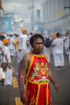 PHUKET, THAILAND - SEPTEMBER 30: Unidentified Mah song pierced weapon to their cheeks, They believed to suffer the pain of devotee during the Phuket Vegetarian Festival. The Festival is a famous annual festival also known as Nine Emperor Gods festival on のeditorial素材