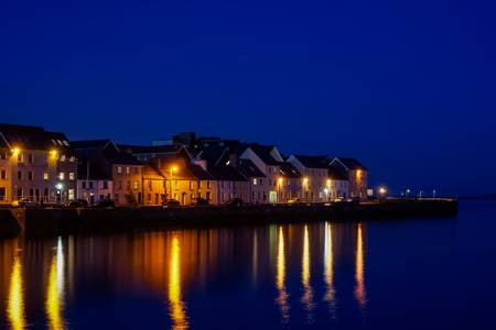 Port of Galway at night with lights reflecting in the water.の写真素材
