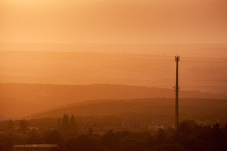 Beautiful sunset with electric tower. Orange and yellow abstract background scene