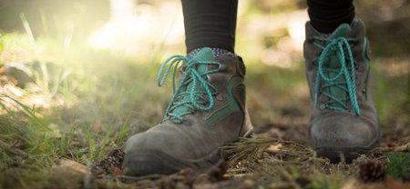 person walking through the forest in nature. Healthy life style. Boots in the foreground