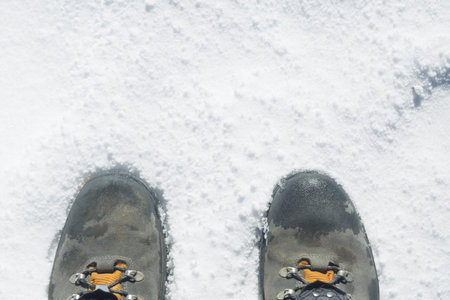 Boots in the snow. Feet isolated on white background with copy space. Adventure sports in winter....