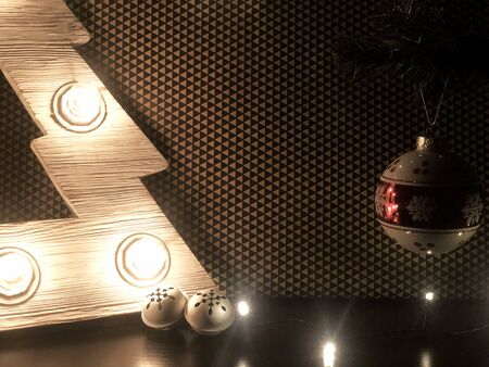 Wooden Christmas tree with lamps. Christmas toys on the table and on christmas tree.の写真素材