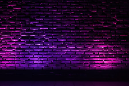Purple brick wall with neon lights. Abstract background for design.の素材