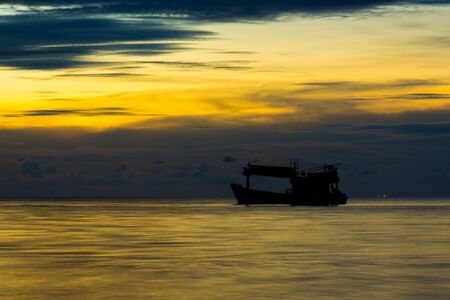 back lit traler on the ocean at sunsetの写真素材