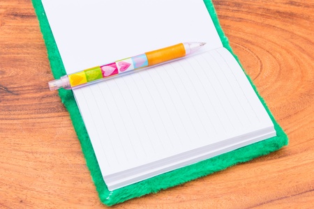velvet Notebook and Pen on wood backgroundの写真素材