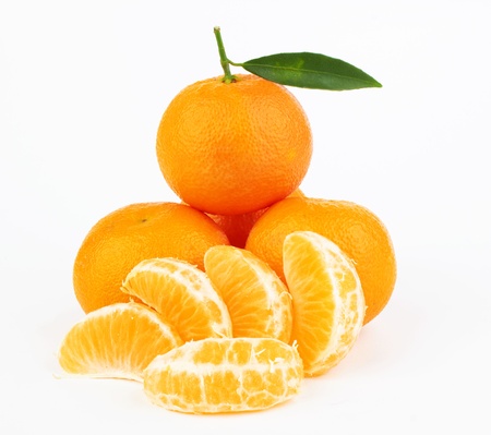 Ripe tangerines with leaves and slices on white backgroundの写真素材