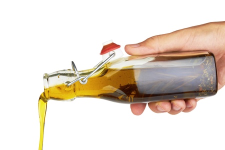 Pouring olive oil isolated on white background の写真素材