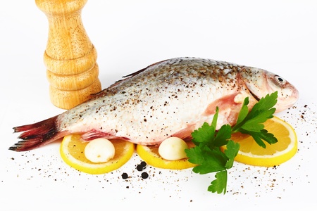 Raw fish with lemon and parsley on white backgroundの写真素材
