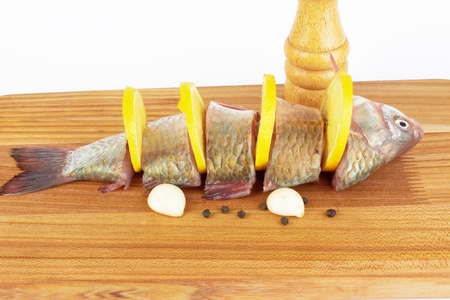 Raw fish with cooking ingredients on a cutting boardの写真素材