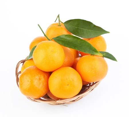 tangerines with leaves in a beautiful basket  on whiteの写真素材