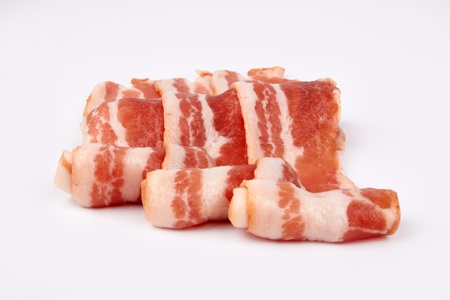 pieces of raw bacon isolated on a white background の写真素材