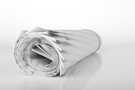 Roll of newspaper isolated on white background の写真素材