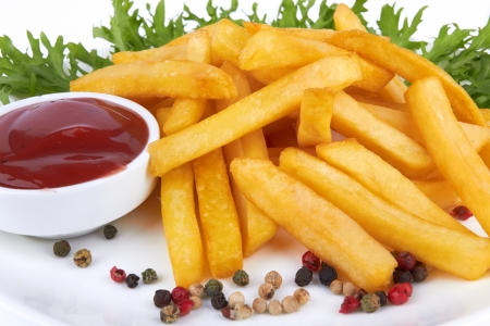 French fries with ketchup closeup over white の写真素材