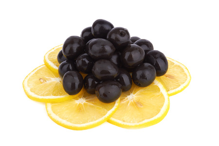 heap of black olives with lemon isolated on a white の写真素材