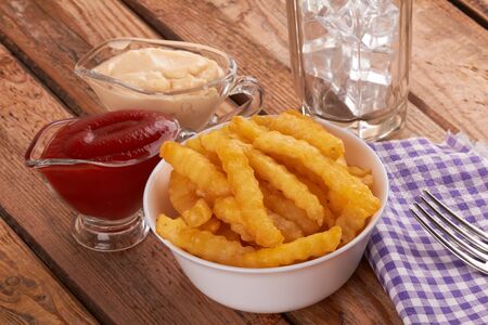 Tasty french fries on wooden table backgroundの写真素材
