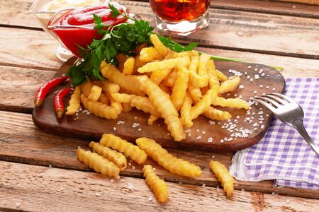 Tasty french fries on wooden table backgroundの写真素材