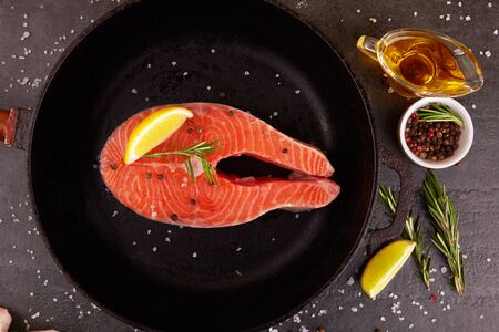 Salmon steak on a pan with spicesの写真素材