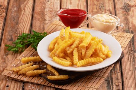 Tasty french fries on wooden table backgroundの写真素材