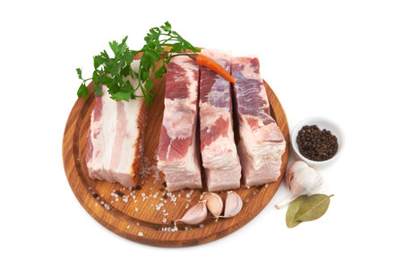 Raw pork belly with streaks of fat with slices on a wooden cutting board isolated on whiteの写真素材