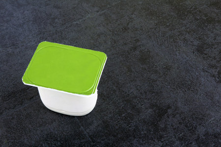 Fruit yogurt on dark stone surfaceの写真素材