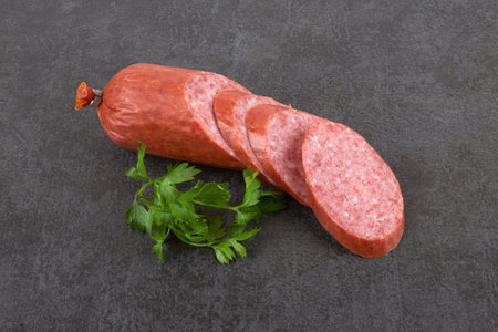 Smoked sausage with parsley on a stone backgroundの写真素材