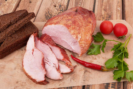 Piece of smoked meat on a wooden surfaceの写真素材