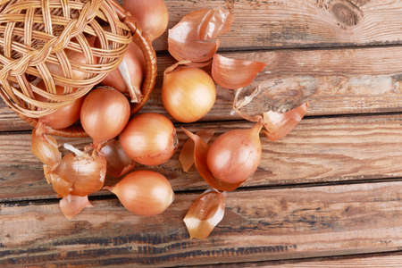 Ripe fresh golden onions on a wooden backgroundの写真素材