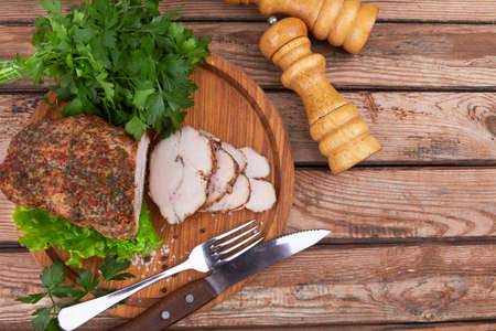 Baked meat on cutting board on wooden surfaceの写真素材