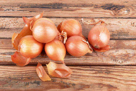 Ripe fresh golden onions on a wooden backgroundの写真素材