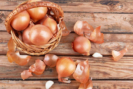 Ripe fresh golden onions on a wooden backgroundの写真素材