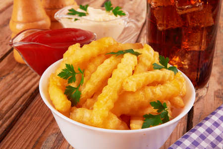 Tasty french fries on wooden table backgroundの写真素材